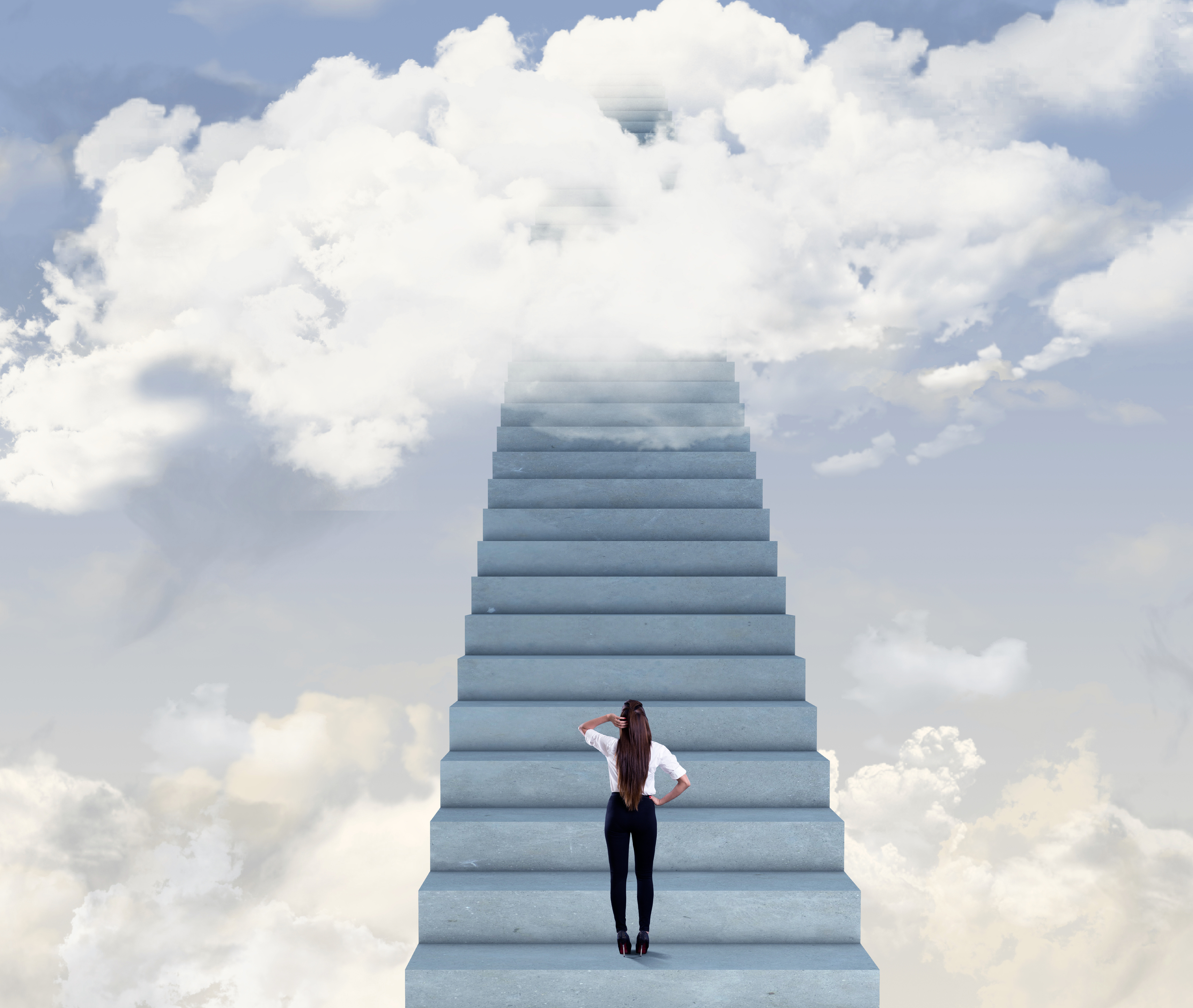 Woman at bottom of stairs looking up into clouds